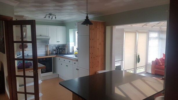 A kitchen with white cabinets, a wooden countertop, and a ceiling with a decorative pattern. - Spacious House, Just Five Minutes Walk From Beach, Perfect for Families/Surfers (Bude)
