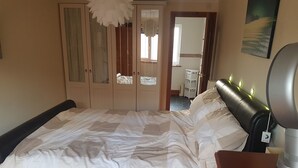 A bedroom with a bed, a dresser, and a wardrobe. - Spacious House, Just Five Minutes Walk From Beach, Perfect for Families/Surfers (Bude)