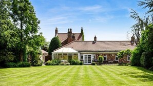 A house with a well-maintained lawn, a conservatory, and a brick facade. - Large open plan cottage in conservation village just outside York. 3 night deals (York)