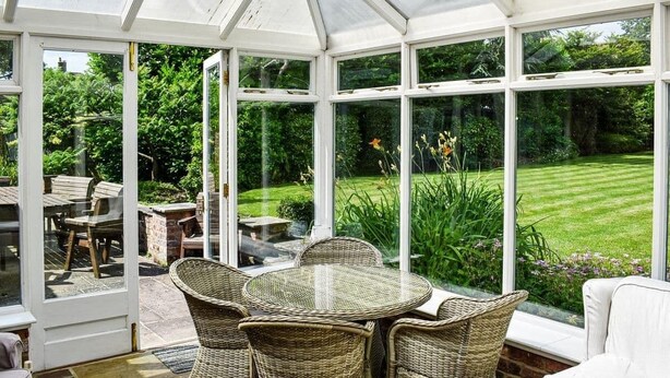 A conservatory with wicker furniture, a glass door leading outside, and a view of a well-maintained garden. - Large open plan cottage in conservation village just outside York. 3 night deals (York)