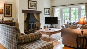 A cozy living room with a fireplace, a television, and comfortable seating. - Large open plan cottage in conservation village just outside York. 3 night deals (York)