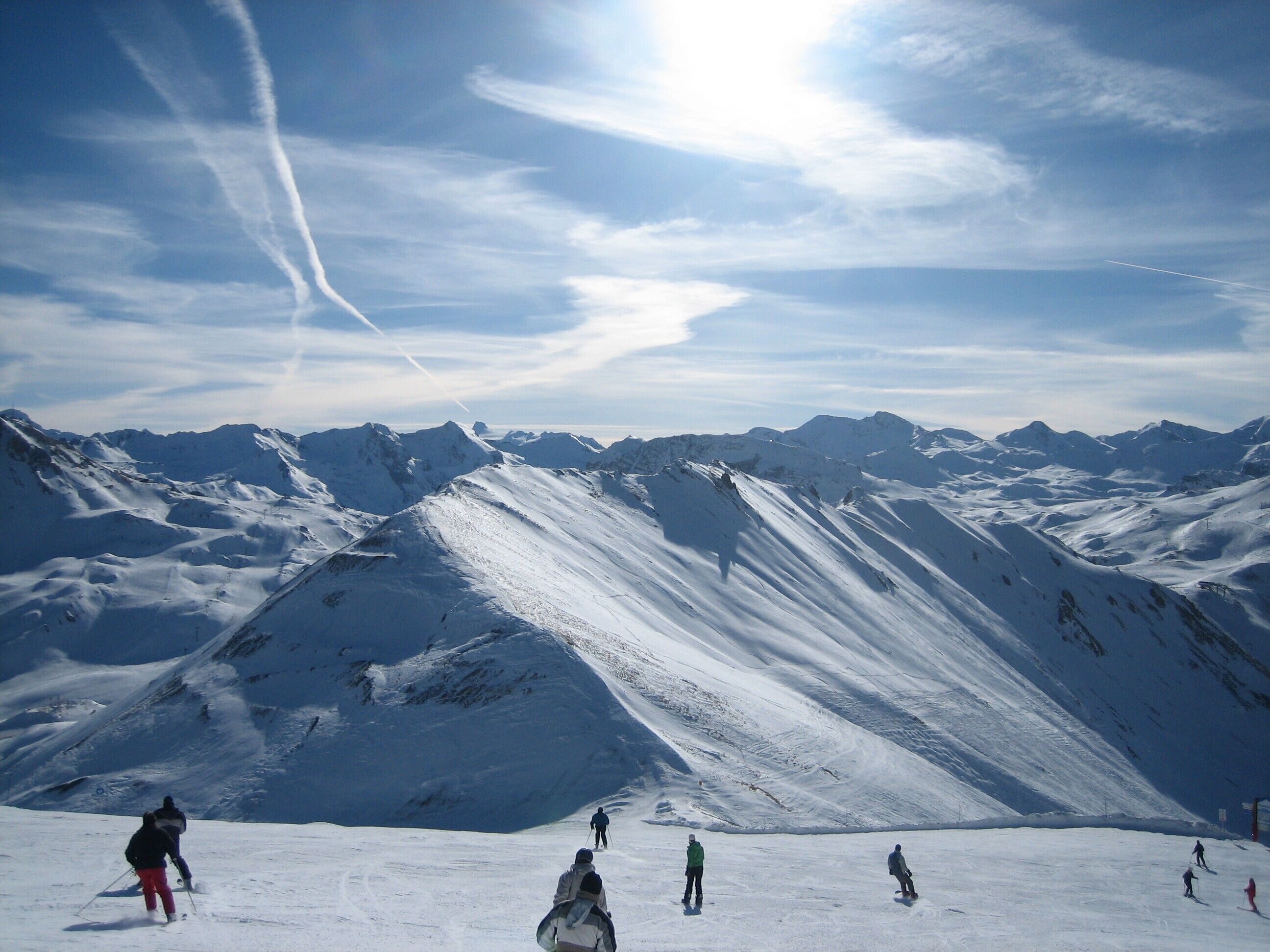Un paysage de montagne enneigé avec des skieurs et des snowboardeurs.