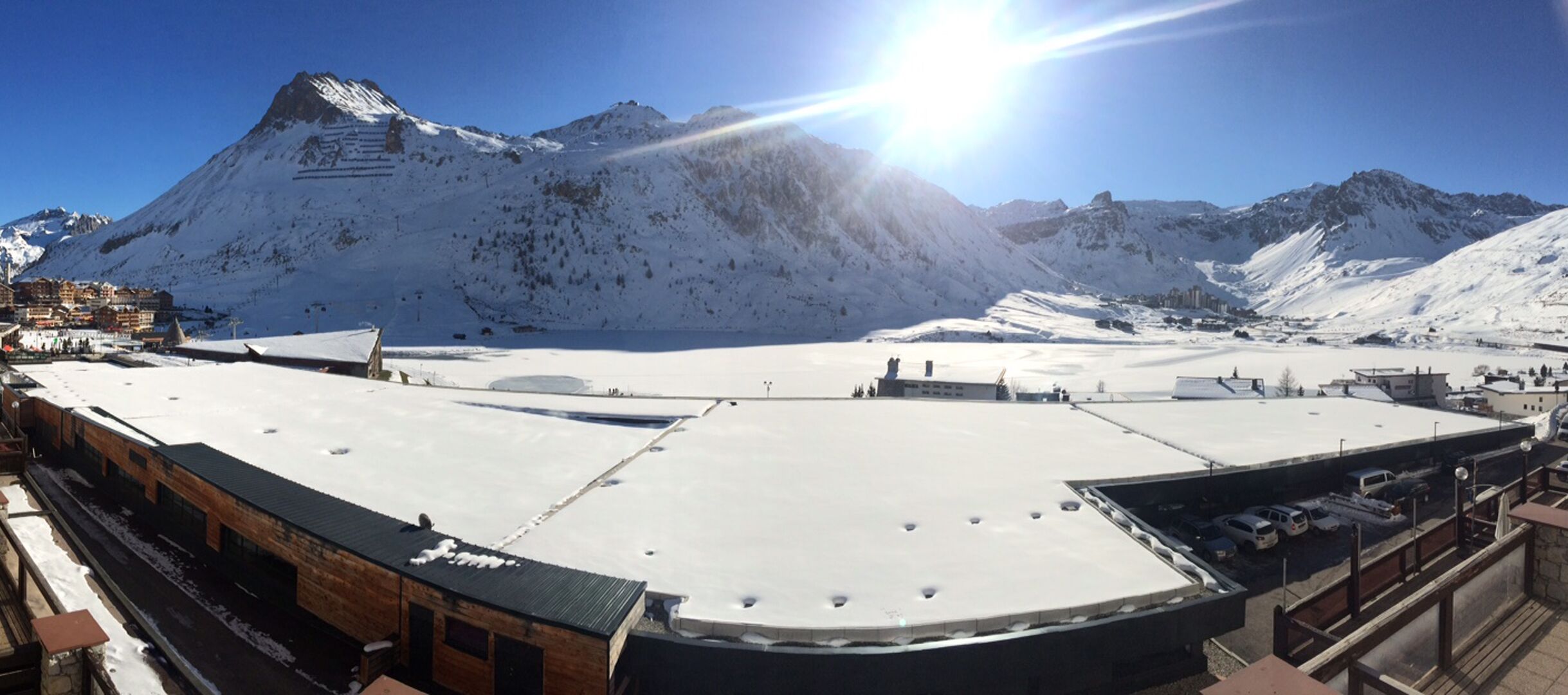 Eine verschneite Berglandschaft mit einem Skiort im Hintergrund.
