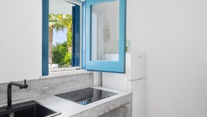 A modern kitchen with a sink, a white refrigerator, and a window with a blue frame. - VACATION HOME 300 MT. BY THE SEA OF FINE GOLDEN SAND WITH PRIVATE POOL (Avola)