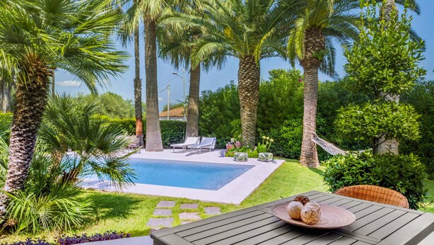 A poolside area with palm trees, a swimming pool, lounge chairs, and a table with decorative items. - VACATION HOME 300 MT. BY THE SEA OF FINE GOLDEN SAND WITH PRIVATE POOL (Avola)