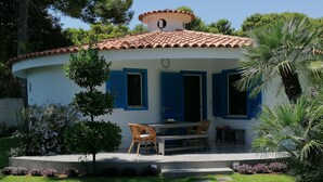 A house with a tiled roof, a pool, and a patio with chairs and a table. - VACATION HOME 300 MT. BY THE SEA OF FINE GOLDEN SAND WITH PRIVATE POOL (Avola)