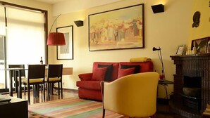 A living room with a red sofa, yellow armchair, and a fireplace. - Porto: OPorto Apartment Triplex (Porto)