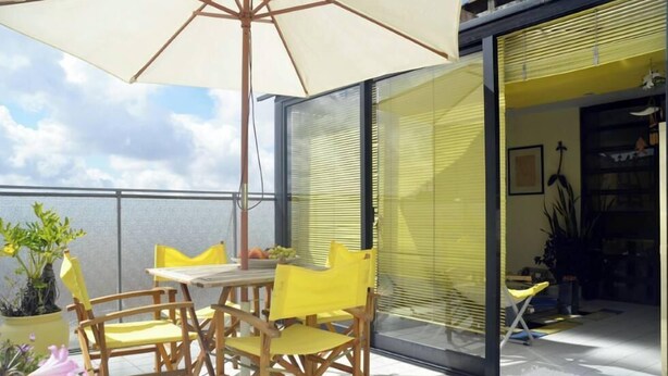 A balcony with a table and chairs, a potted plant, and a sliding glass door leading to an interior space. - Porto: OPorto Apartment Triplex (Porto)