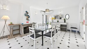 Una cocina moderna con armarios blancos, una mesa de comedor y sillas.