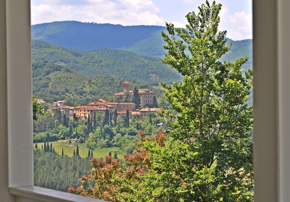 A view of a hillside village with traditional buildings and lush greenery.