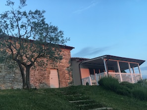 Un edificio in pietra con una porta di legno e un portico coperto.