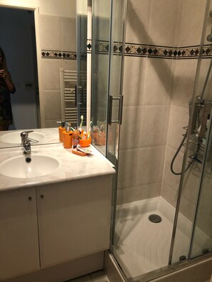 Een bad/douchecombinatie, een haardroger, handdoeken, zeep