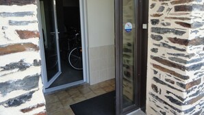 A doorway leading to a room with a tiled floor and a doormat. - 7 km from DERVAL, stone house 4/5 adults + 1 baby. INTERNET BOX. (Conquereuil)