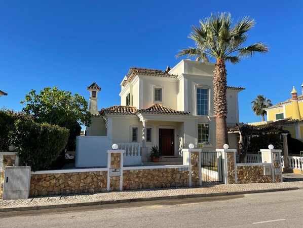 A two-story house with a stone facade, a tiled roof, and a palm tree in front. - Algarve, Almancil: Fully secluded villa with private pool urb. Varandas do Lago. (Almancil)