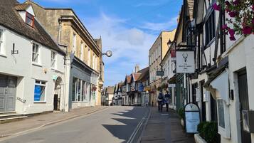 Une vue de rue avec un bâtiment portant l’inscription « The White Hart Inn » et un panneau indiquant « Salle de réception ».
