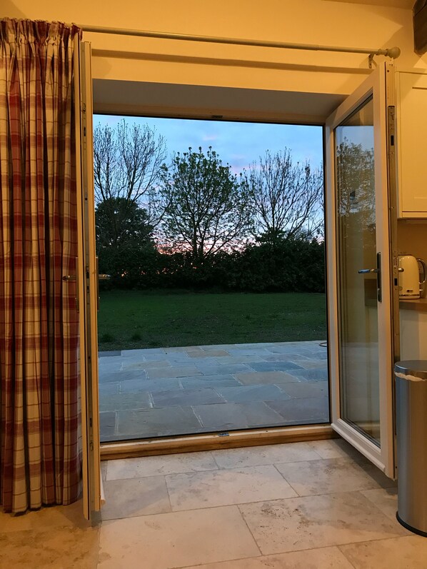 A room with a sliding glass door leading to a patio with a stone floor. - Stables at Todds House Farm (Stockton on Tees)