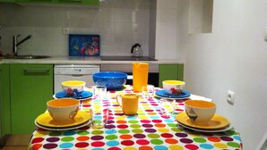 A kitchen with green cabinets, a colorful polka dot tablecloth, and various kitchenware. - Castle / Alfama in the historic center (Lisboa)