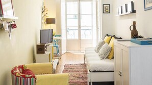 A cozy living room with a sofa, a television, and a bookshelf. - Castle / Alfama in the historic center (Lisboa)