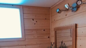 A wooden bathroom with a window, a shelf with plants, a small stool, and a hairdryer. - 2 bedroom apt, balcony facing Mont Blanc, very close to village & GM ski lift (Chamonix-Mont-Blanc)