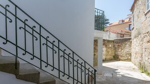 Eine Treppe mit Metallgeländer, das zu einem Hauseingang führt.
