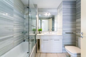 Een bad/douchecombinatie, een haardroger, een bidet, handdoeken