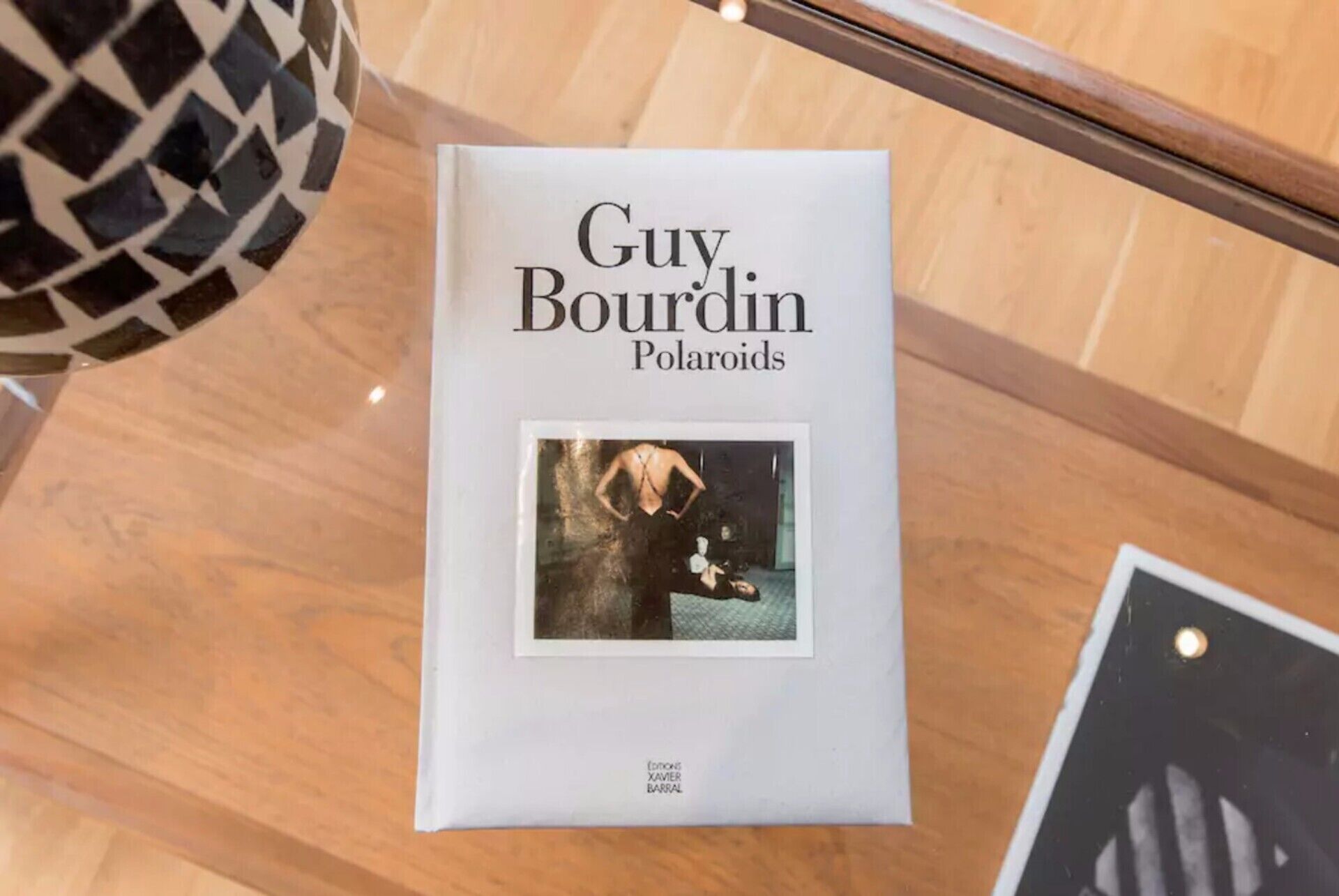 Un livre intitulé « Guy Bourdin, Polaroids », dont la couverture présente une photographie.