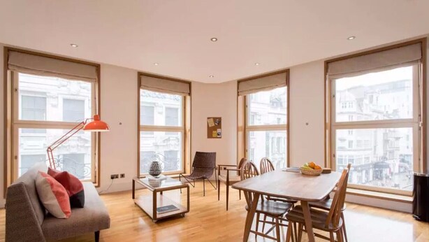 Une pièce spacieuse comprenant une table à manger, des chaises, un canapé et un lampadaire.