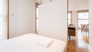 Une chambre d’hôtel comprenant un lit, un bureau et un coin repas avec des chaises.
