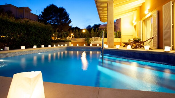Una piscina con zona cubierta y sillas de descanso.