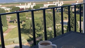 A balcony with a table set for breakfast, including a bowl of cereal with bananas, a cup of coffee, and a glass of orange juice. The view includes a rural landscape with houses and greenery. - 2 Bedroom Penthouse Apartment With Large Sun Terrace (Torre-Pacheco)