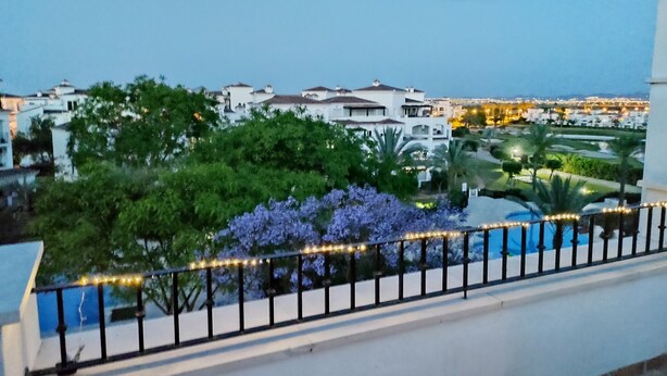 A balcony with a view of a cityscape, including buildings and a landscaped area with trees and a pool. - 2 Bedroom Penthouse Apartment With Large Sun Terrace (Torre-Pacheco)