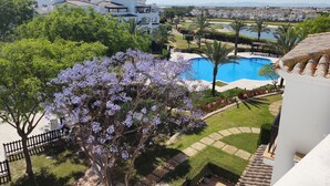A view of a residential area with a swimming pool surrounded by greenery and a clear sky. - 2 Bedroom Penthouse Apartment With Large Sun Terrace (Torre-Pacheco)