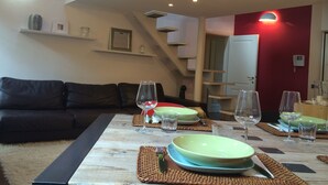 A dining area with a wooden table set for four, a staircase, and a red accent wall. - Very central, On 2 levels, fully renovated, ideal for families  (Como)