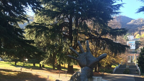 A sculpture of a hand reaching out in a park with trees and a building in the background. - Very central, On 2 levels, fully renovated, ideal for families  (Como)