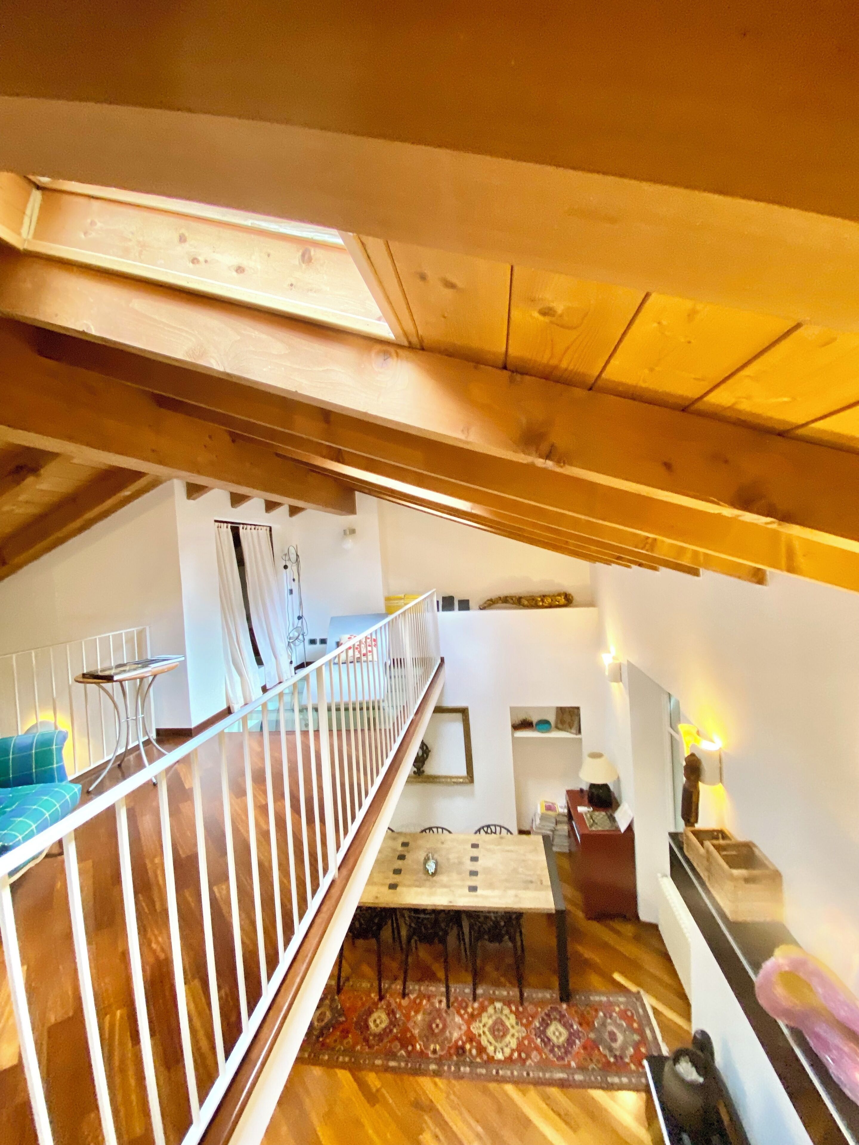 Une pièce de style loft avec un plafond en bois, une table à manger et un canapé.