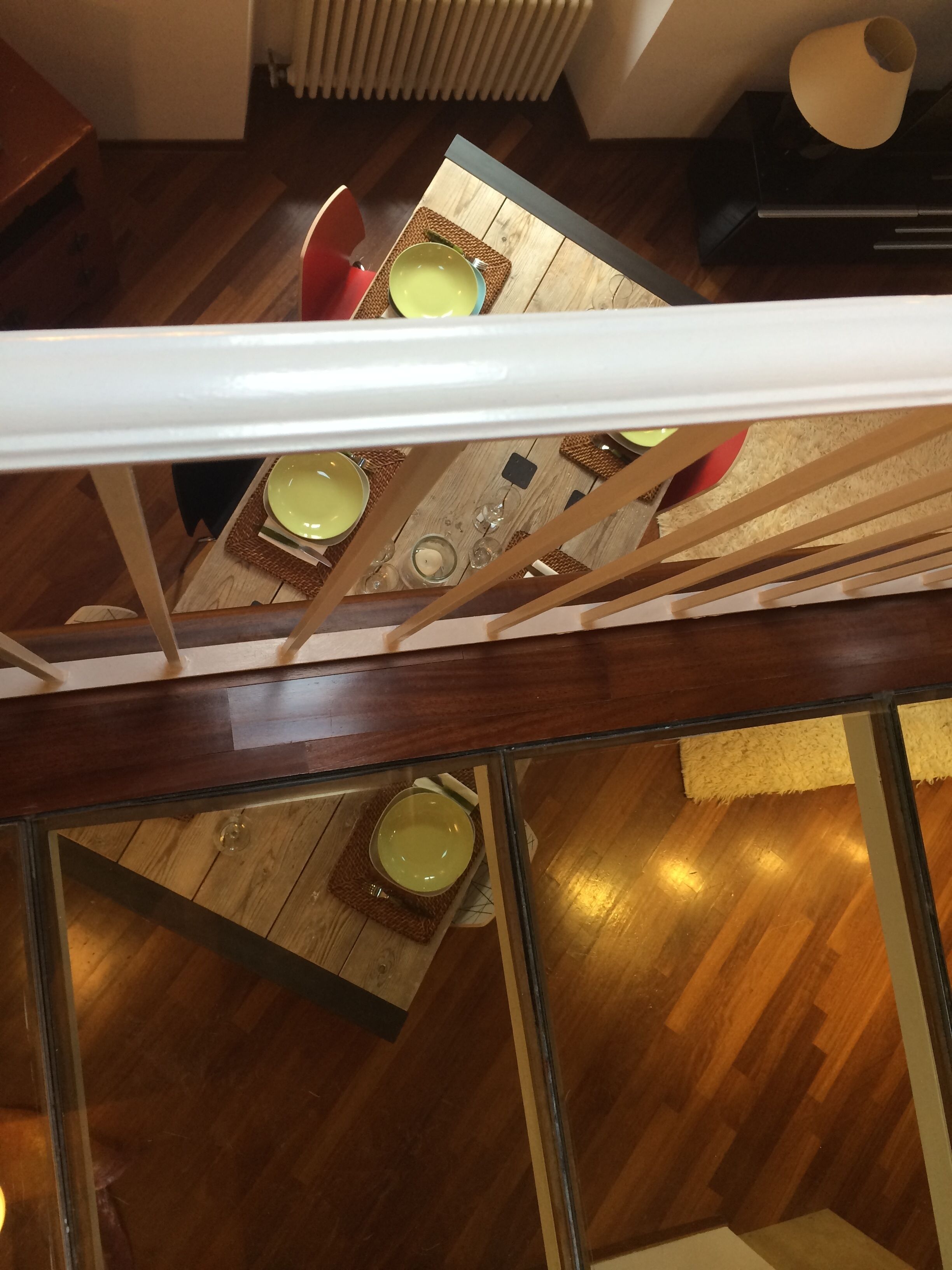 A dining area with a wooden table, chairs, and a glass partition.