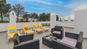 A rooftop terrace with yellow and black wicker furniture, white walls, and a clear sky. - Luxury Spacious 3 Bedroom Duplex Apartment With Sea Views & Salt Water Pool! (Loulé)