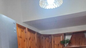 Una cocina con gabinetes de madera, un refrigerador de acero inoxidable, un fregadero y una estufa.