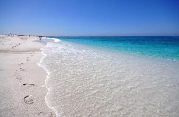Enjoy a serene beach experience with calm waters and a sandy shore.