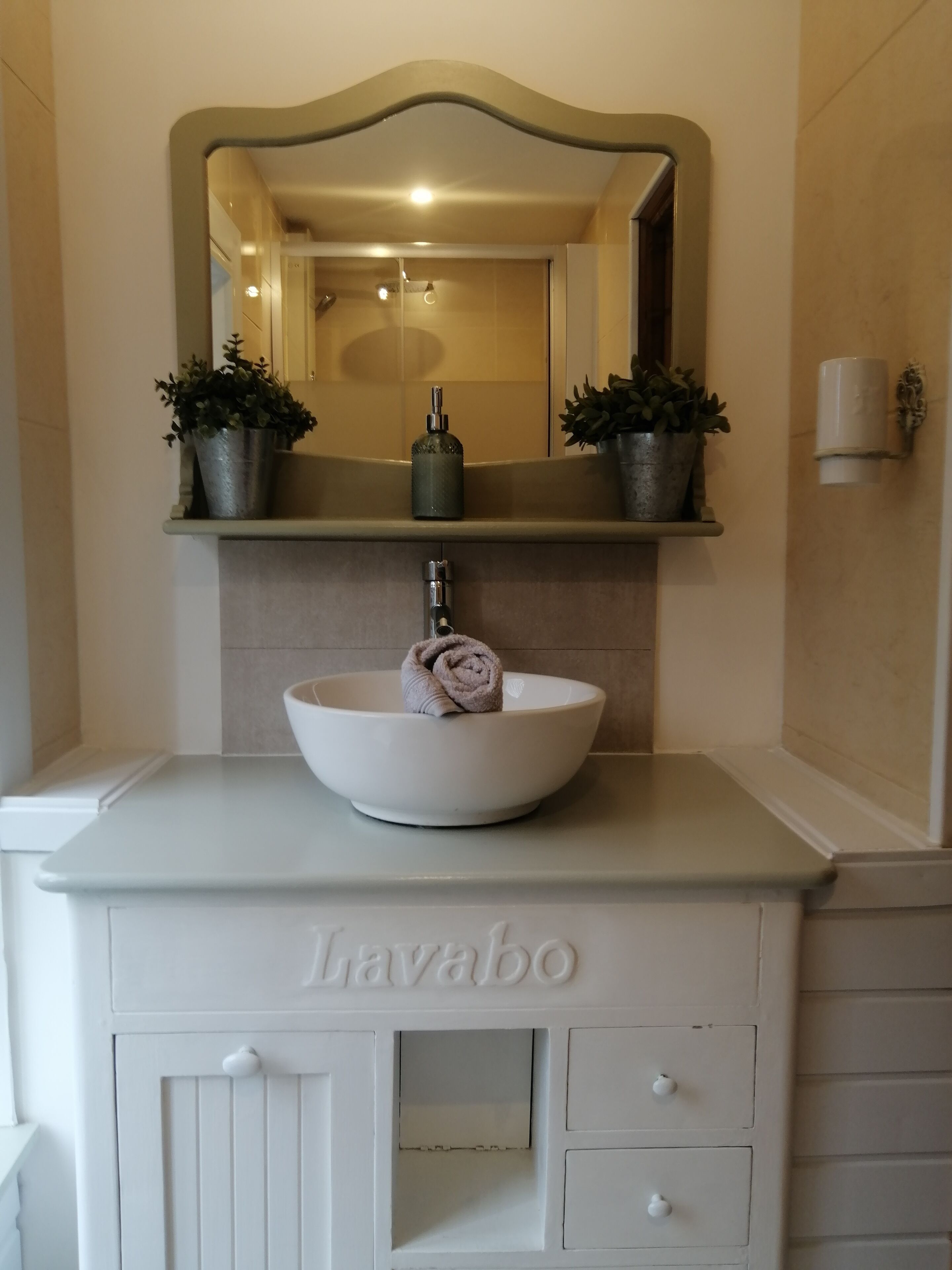 A bathroom vanity with a sink, mirror, and a towel.