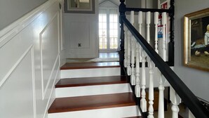 A staircase with white and brown steps, white balusters, and a black handrail. - Monte & Mar House (Camargo)
