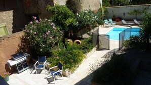 A backyard with a swimming pool, a barbecue grill, and lounge chairs. - Lovely house, garden with pool in tranquil village near coast and countryside (Raissac-D'aude)