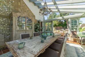 A rustic dining area with a wooden table, chairs, and a chandelier. - The Old School House (W), Warham, Norfolk (Warham)