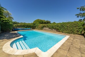 A rectangular swimming pool with a tiled edge, surrounded by a stone deck. - The Old School House (W), Warham, Norfolk (Warham)