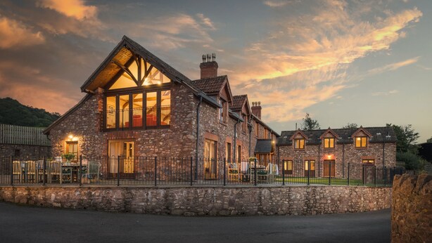 A stone building with a large bay window and a sloped roof. - Luxury Farmhouse with Stunning Somerset Views (Taunton)
