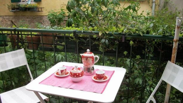 A small outdoor table with a pink tablecloth, two white chairs, and a tea set. - Venice historic center 5 minutes from the Rialto Bridge (Venezia)
