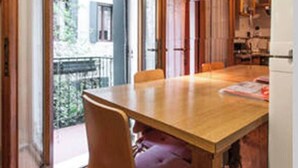 A dining area with a wooden table and chairs, a refrigerator, and a view of the outside through a glass door. - Venice historic center 5 minutes from the Rialto Bridge (Venezia)
