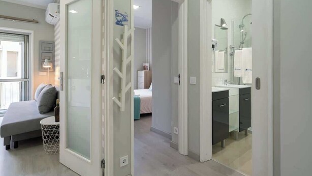 A modern bedroom with a bed, bedside table, and a window. - Sweet Cozy Flat w/ Balcony by HostWise (Porto)