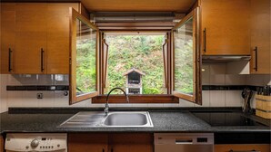 A kitchen with wooden cabinets, a stainless steel sink, and a built-in dishwasher.