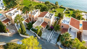 Zona residencial con varias casas, cada una con una terraza en la azotea y mobiliario exterior.